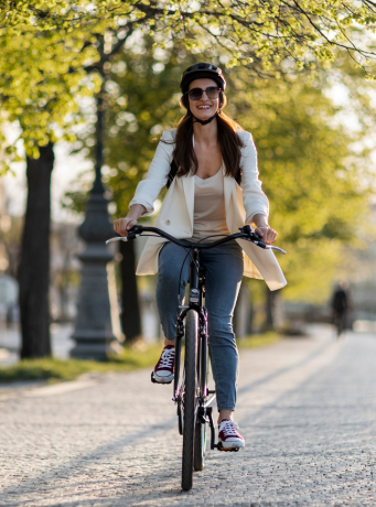 Femme en train de faire du velo dans une rue arborée