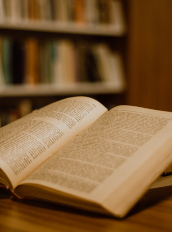 Un livre ouvert sur une table, dans ce qui semble être une bibliothèque