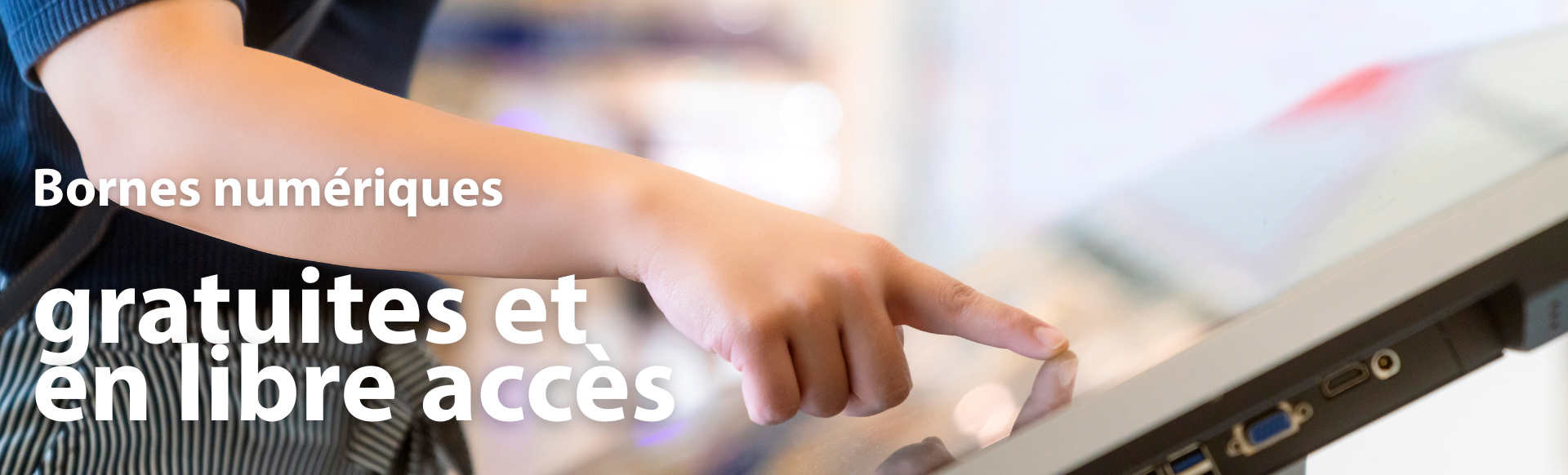 Une main qui touche l'écran tactile d'une borne numérique