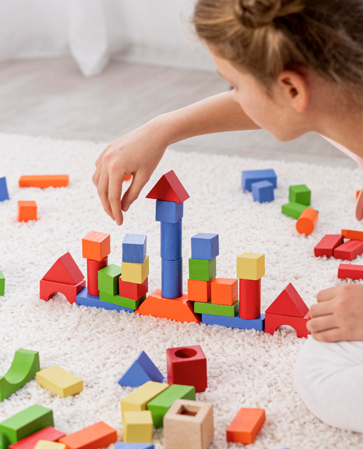 enfant qui joue avec des cubes colorés en bois
