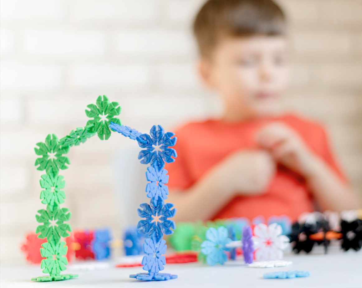 enfant qui joue avec des clips colorés